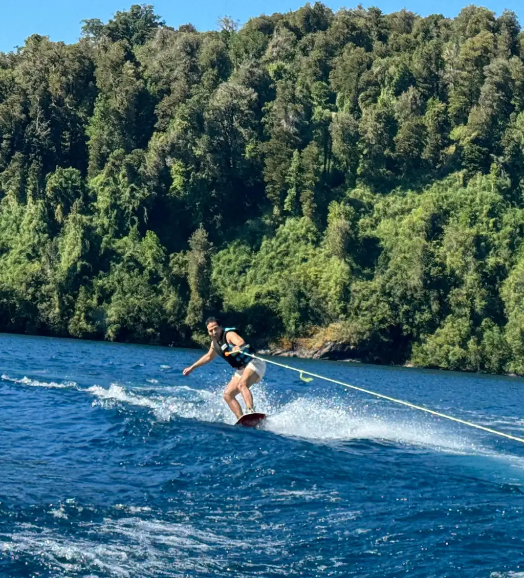 Instructor demonstrating water skiing technique on calm lake